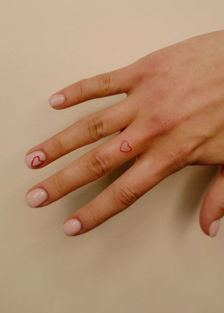 Simple ⁢red ink heart finger ⁣tattoos