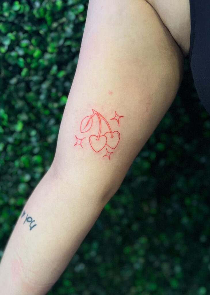 cherries & sparkles⁢ red ink‌ arm tattoo